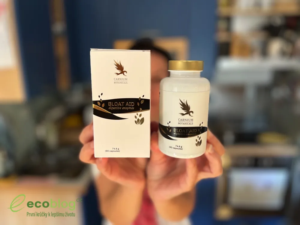 Ruce drží krabičku a dózu Bloat Aid od Carnium Botanicals