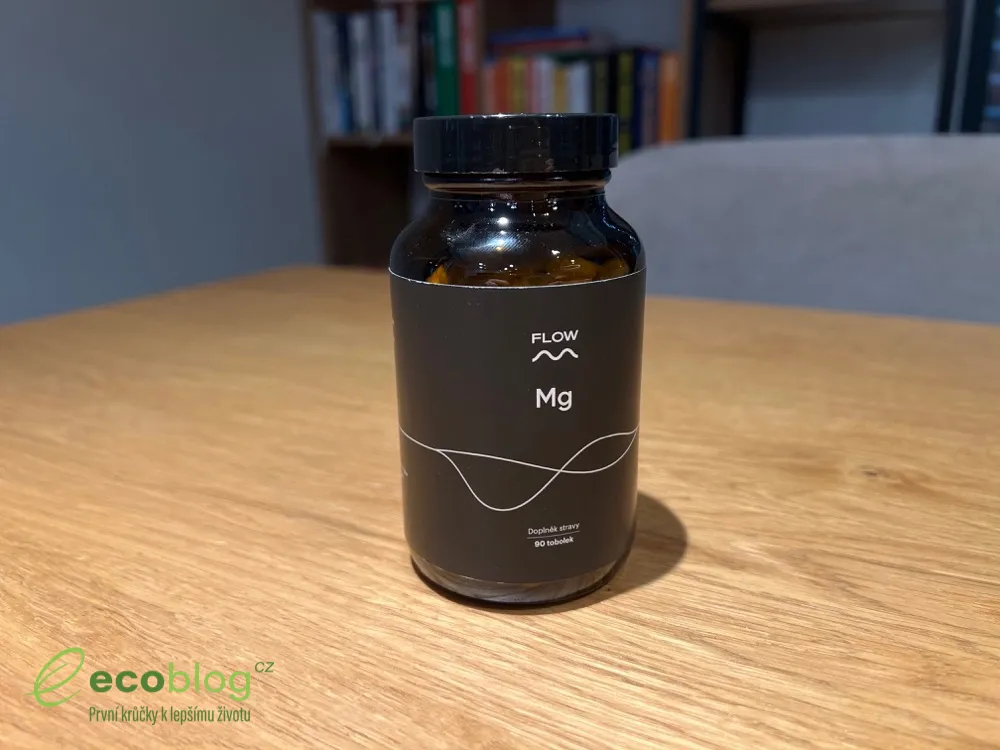 Lahvička Flow Nutrition Digest na dřevěném stole s knihovnou v pozadí