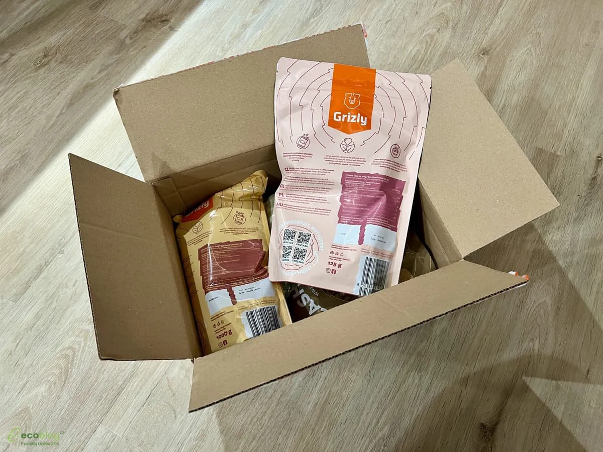 Otevřená papírová krabice z e-shopu Grizly s úhledně zabalenými sáčky uvnitř