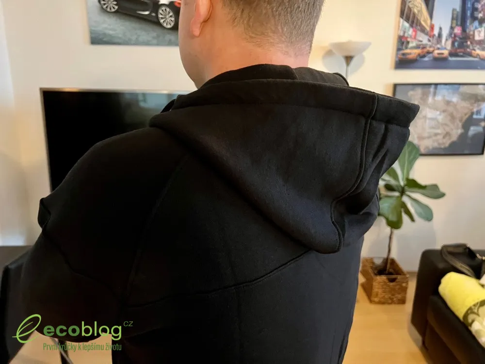 Muž zezadu v černé mikině Iron Aesthetics s kapucí v obývacím pokoji