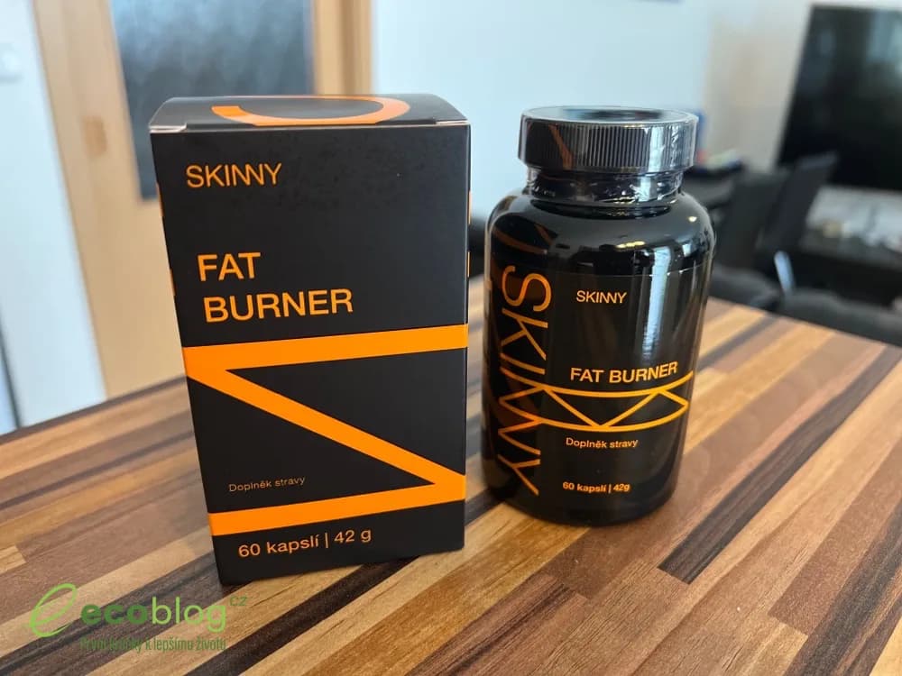 Černá dóza Skinny Fat Burner s bílými kapslemi ve víčku na dřevěném stole