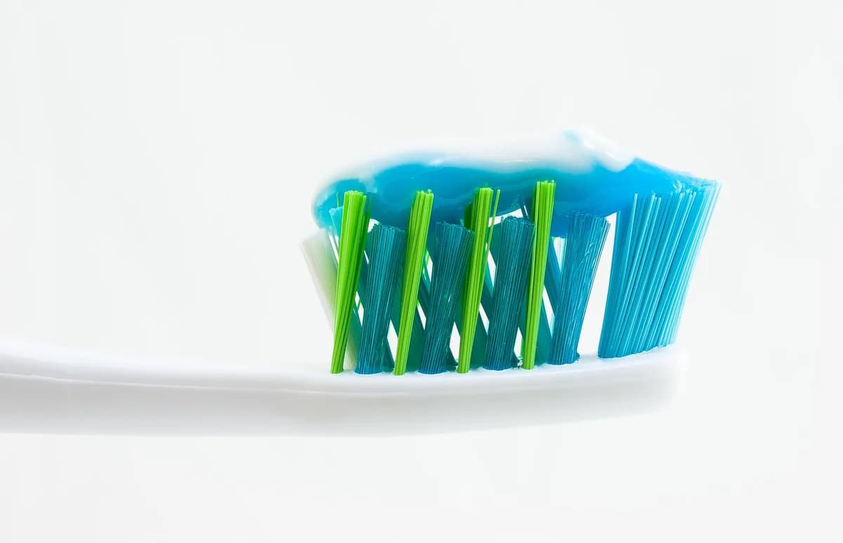 Zubní kartáček s nanesenou zubní pastou jako symbol každodenní ústní hygieny